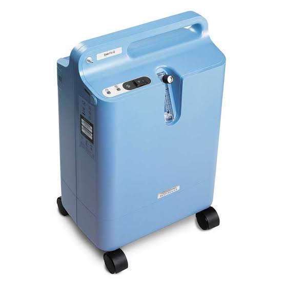 Home oxygen concentrator beside a living room chair